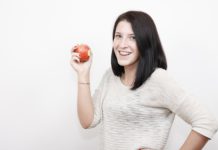 Best fruits for acne. A girl eating an apple
