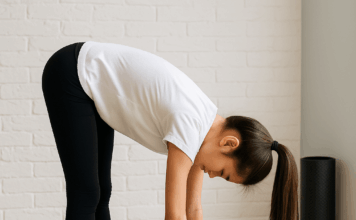 Pre-SAT Stretching & Breathing Exercises for Teen Focus Teen girl doing a forward fold stretch on a yoga mat before the SAT exam